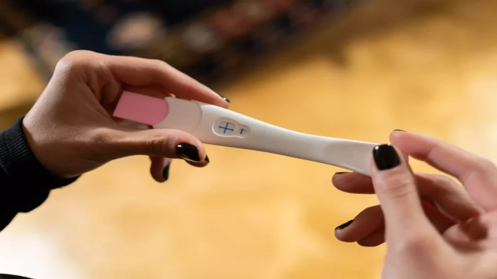 Test de grossesse quand le faire : un plus apparaît dans la fenêtre du test, indiquant un résultat positif.